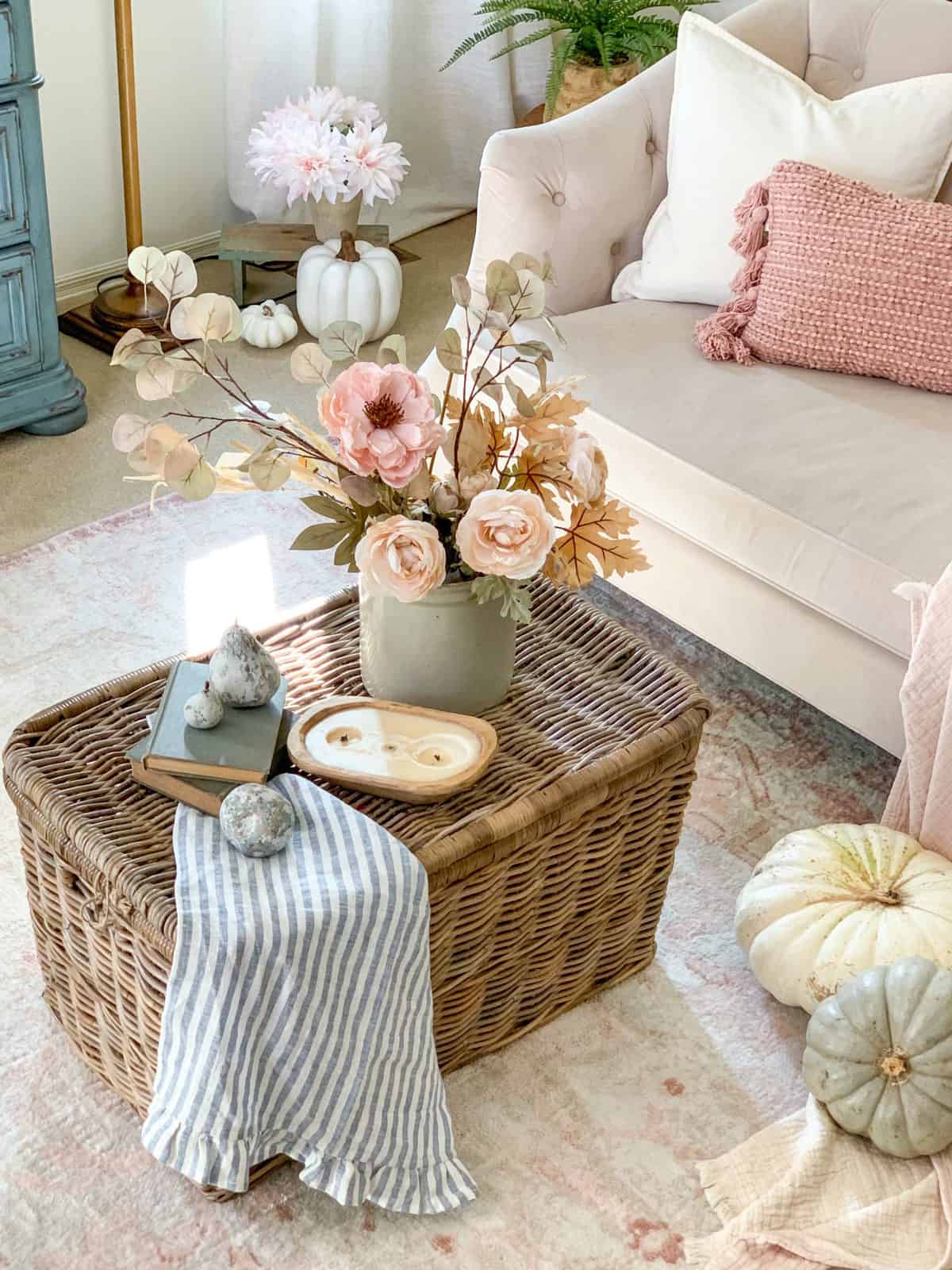 Coffee table decor on top of a lidded basket in a living room.