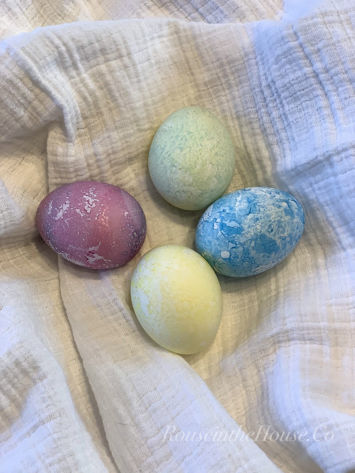 Four dyed Easter Eggs on a muslin cloth.