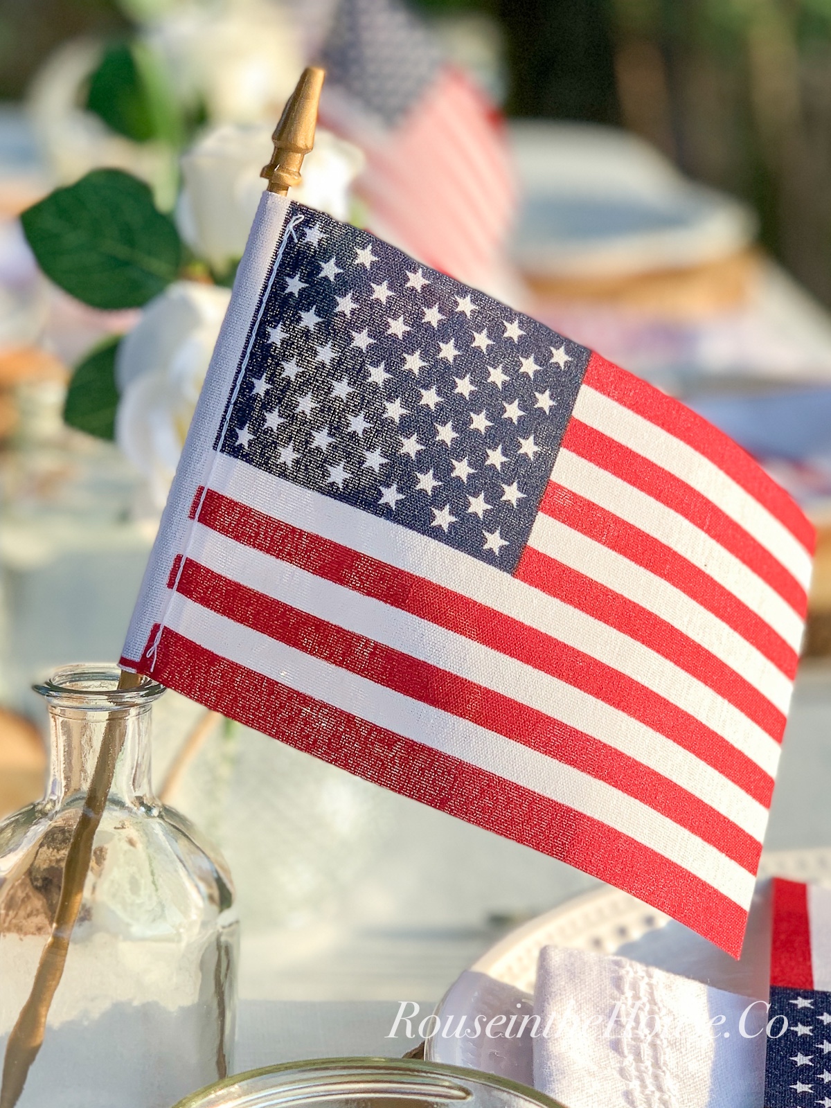 A small American flag is used as table decor on a July 4th tablescape.