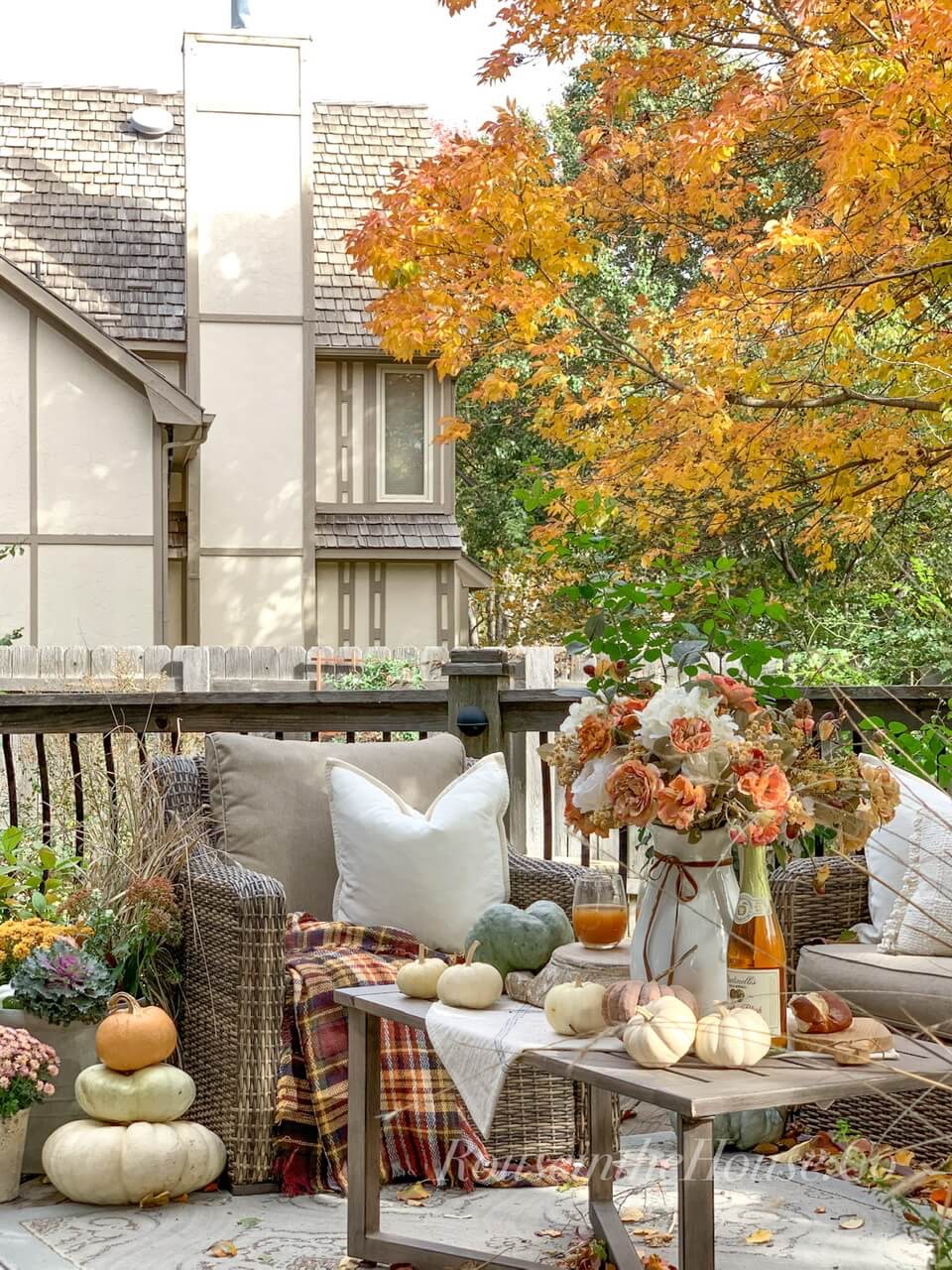 Cozy fall deck decor: including a fall planter, a pumpkin stack, fall table decor, lots of pillows and throws.